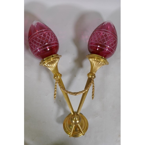 118 - A pair of ormolu two branch wall lights with cranberry glass shades, 57cm long