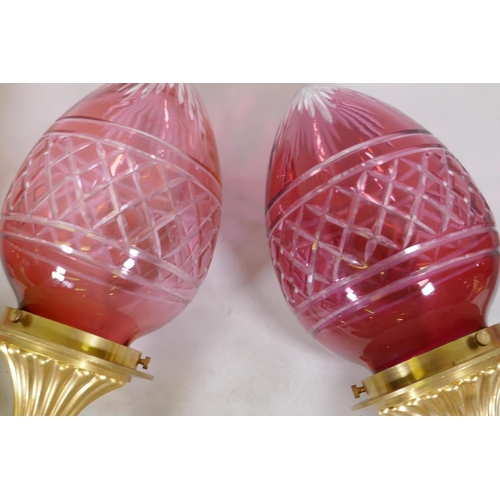 118 - A pair of ormolu two branch wall lights with cranberry glass shades, 57cm long