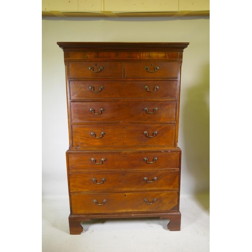 1186 - A Georgian mahogany chest on chest in two sections, with dentil cornice over a blind frieze and two ... 