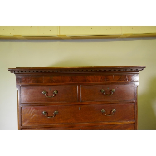 1186 - A Georgian mahogany chest on chest in two sections, with dentil cornice over a blind frieze and two ... 