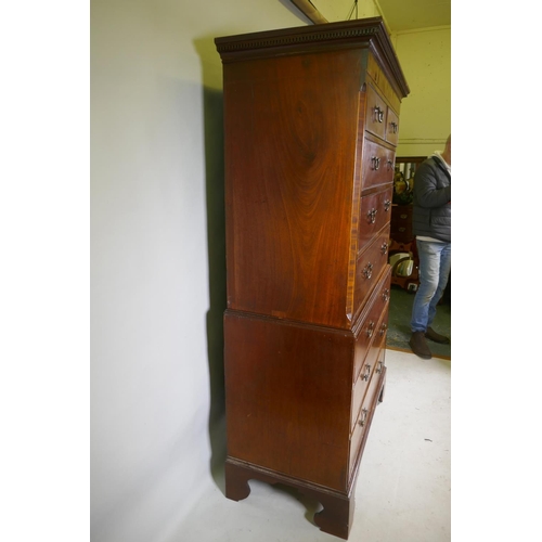 1186 - A Georgian mahogany chest on chest in two sections, with dentil cornice over a blind frieze and two ... 