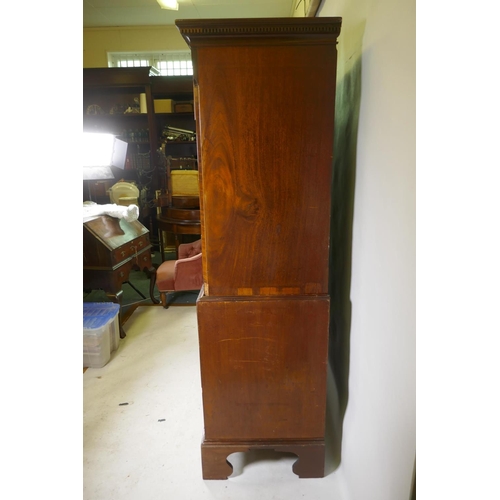 1186 - A Georgian mahogany chest on chest in two sections, with dentil cornice over a blind frieze and two ... 