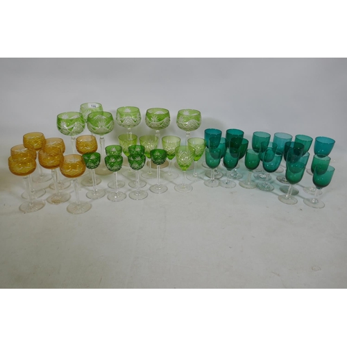 128 - A quantity of matched green and yellow cut wine glasses, and green drinking glasses