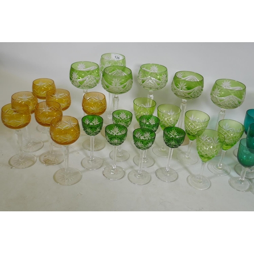 128 - A quantity of matched green and yellow cut wine glasses, and green drinking glasses