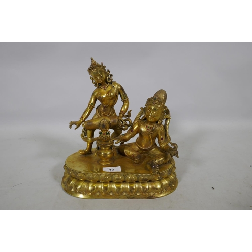 13 - An Oriental gilt bronze figure group, Buddha accompanied by a female musician, 29cm high