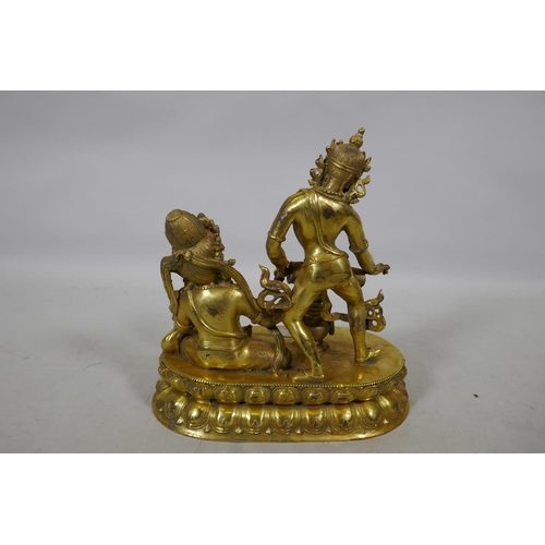 13 - An Oriental gilt bronze figure group, Buddha accompanied by a female musician, 29cm high