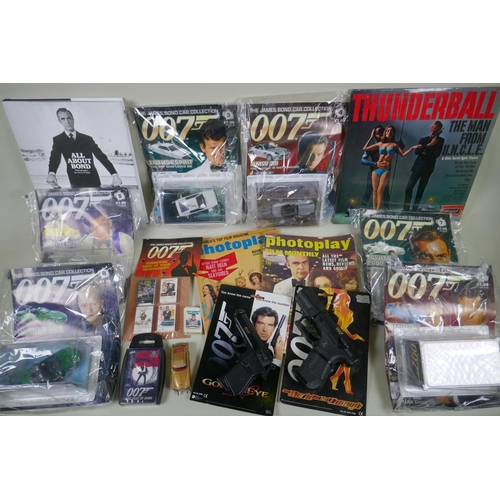 134 - A quantity of James Bond collectors' items to include magazines, reproduction plastic guns, match bo... 