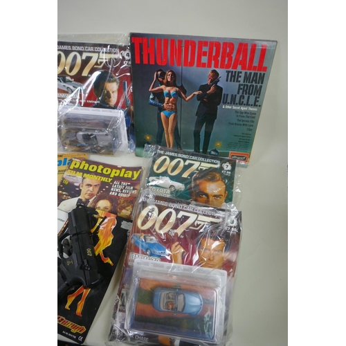 134 - A quantity of James Bond collectors' items to include magazines, reproduction plastic guns, match bo... 