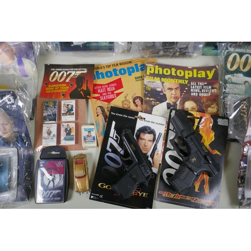 134 - A quantity of James Bond collectors' items to include magazines, reproduction plastic guns, match bo... 