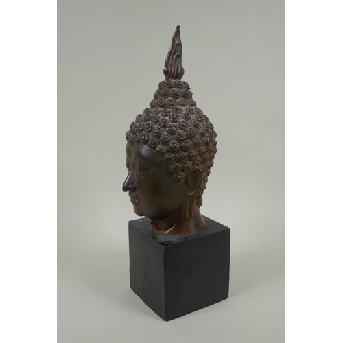 136 - A Thai bronzed metal head bust of Buddha, on a display stand, 35cm high