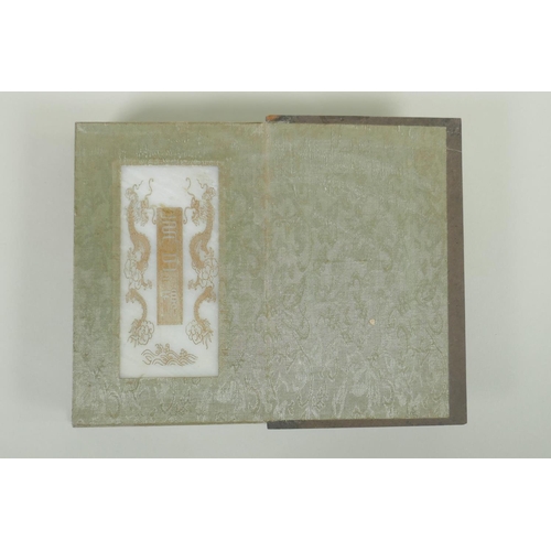 148 - A Chinese wood and silk bound book with white jade tablet pages bearing chased and gilt inscriptions... 