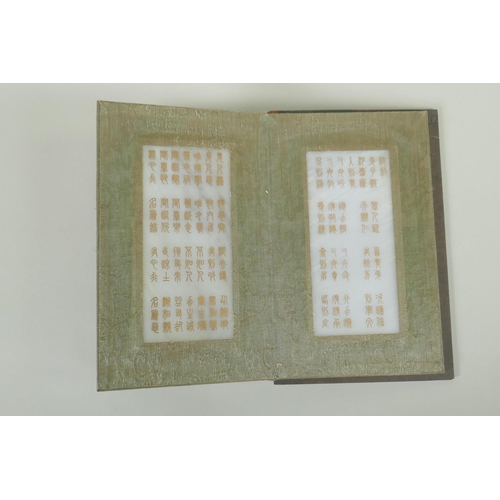 148 - A Chinese wood and silk bound book with white jade tablet pages bearing chased and gilt inscriptions... 