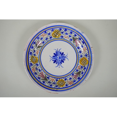 15 - An antique Delft plate decorated with a floral design, 32cm diameter