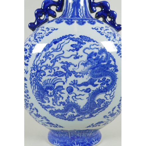 150 - A Chinese blue and white porcelain two handled moon flask, decorated with dragon, phoenix and lotus ... 