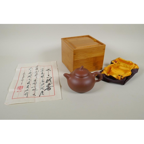 151 - A Chinese YiXing teapot with fitted box, silk bag and documentation, seal mark to base