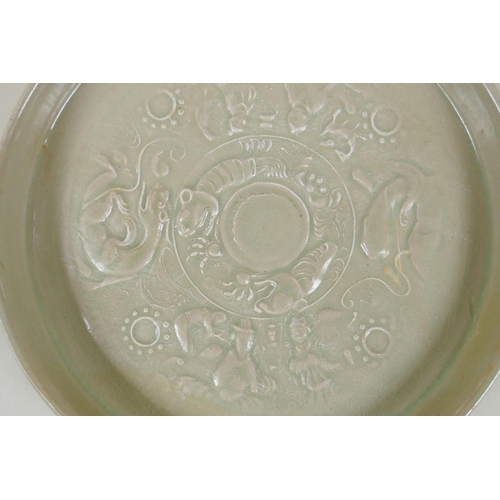 153 - A Chinese celadon glazed porcelain shallow dish, with underglaze decoration of figures, dragons and ... 