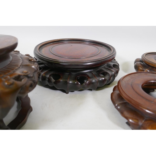 179 - Nine Chinese hardwood vase stands with carved lotus decoration, and a carved jar cover