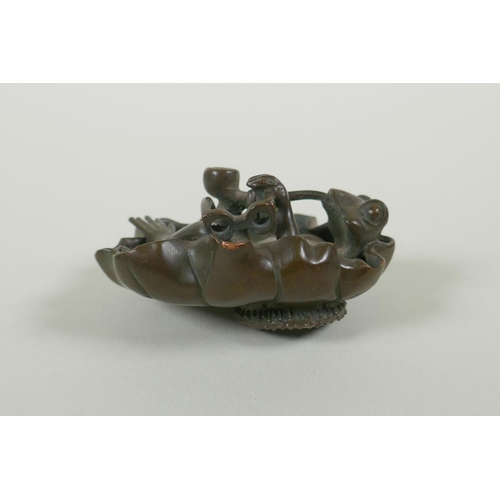 191 - A bronze figure of a smoking frog reclining on a lily pad, 8cm diameter