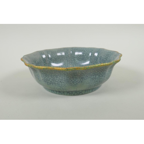 195 - A Chinese celadon crackleware bowl of lobed form, with a gilt metal rim and chased character inscrip... 