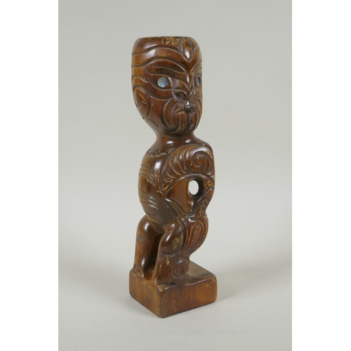 222 - A Maori carved wood Tiki figure with abalone eyes, 28cm high