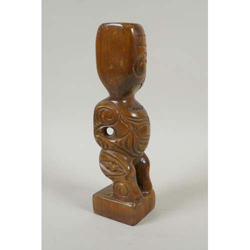 222 - A Maori carved wood Tiki figure with abalone eyes, 28cm high