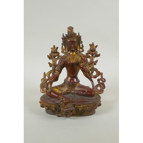 228 - A Tibetan bronze figure of white tara with gilt and copper patina, 20cm high