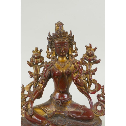 228 - A Tibetan bronze figure of white tara with gilt and copper patina, 20cm high