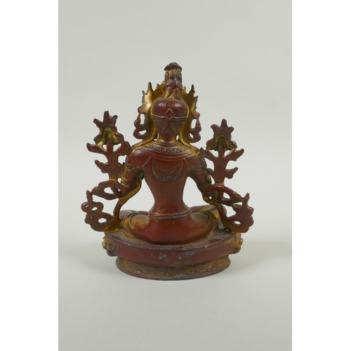 228 - A Tibetan bronze figure of white tara with gilt and copper patina, 20cm high