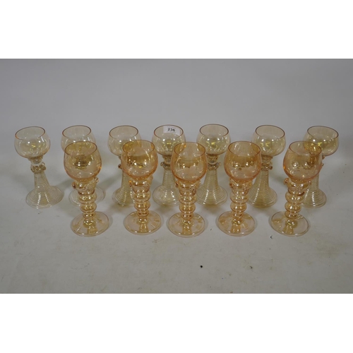 236 - A set of seven C19th amber coloured Hock wine glasses, and five more similar with etched grape and v... 