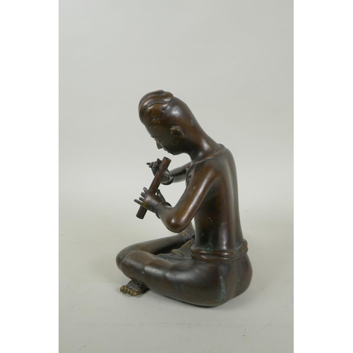 249 - A Thai filled bronze figure of a musician playing the flute, 23cm high