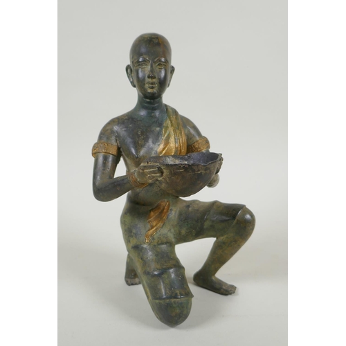 29 - An antique oriental filled bronze figure of a kneeling woman carrying a bowl, 24cm high