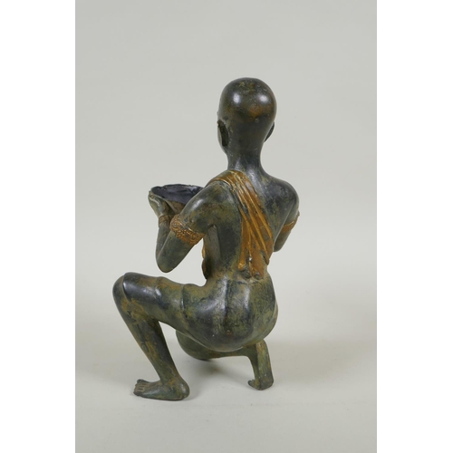 29 - An antique oriental filled bronze figure of a kneeling woman carrying a bowl, 24cm high