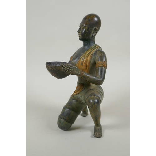 29 - An antique oriental filled bronze figure of a kneeling woman carrying a bowl, 24cm high