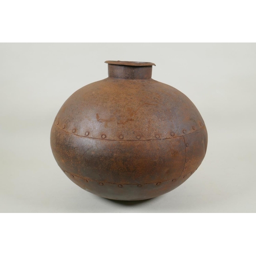 295 - An Indian riveted metal water pot, 30cm high, 35cm diameter