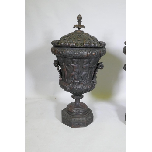 297 - A pair of carved wood urns and covers with classical style decoration of putti riding a goat, 87cm h... 