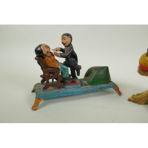 322 - A painted cast iron money box in the form of a dentist, 22cm long, and a vintage clockwork money