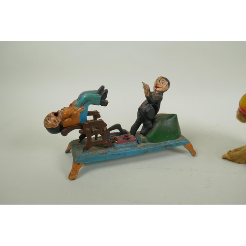 322 - A painted cast iron money box in the form of a dentist, 22cm long, and a vintage clockwork money