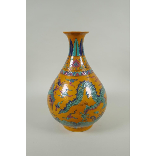 40 - A Chinese yellow ground porcelain pear shaped vase with enamel decoration of a dragon and phoenix, X... 