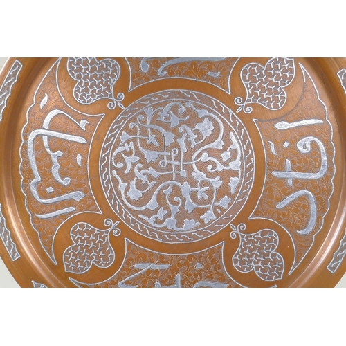 43 - An Islamic silver overlaid copper tray with caligraphic script decoration, 55cm diameter