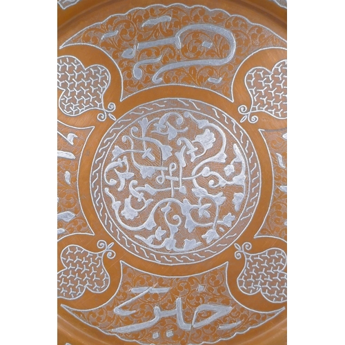 43 - An Islamic silver overlaid copper tray with caligraphic script decoration, 55cm diameter