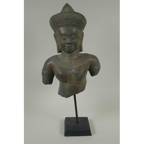 45 - A Cambodian bronze bust of a female deity, on a display stand, 44cm high