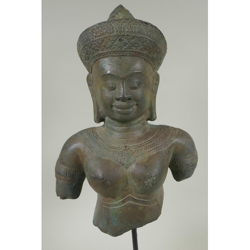 45 - A Cambodian bronze bust of a female deity, on a display stand, 44cm high