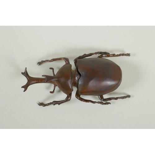 51 - A Japanese style bronze okimono rhinoceros beetle, 9cm long