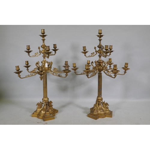 59 - A pair of ormolu brass nine branch candelabra with ram's mask decoration, raised on fluted columns s... 