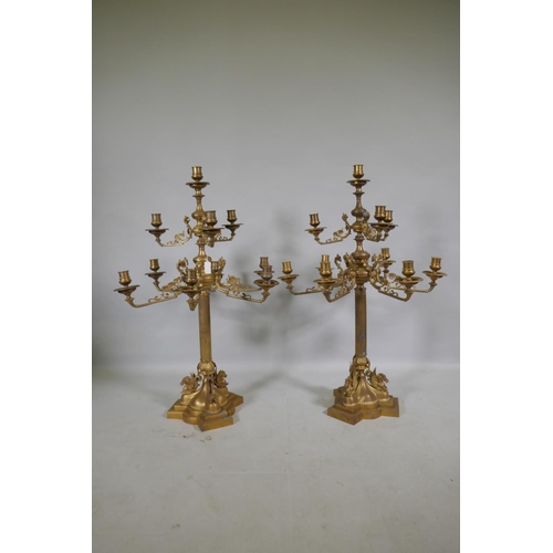 59 - A pair of ormolu brass nine branch candelabra with ram's mask decoration, raised on fluted columns s... 