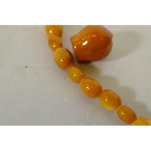 608 - A vintage amber bead necklace and two loose beads, 24g, 36cm long