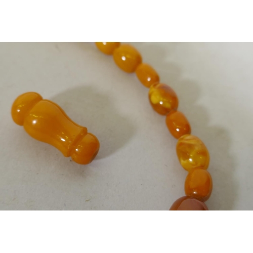 608 - A vintage amber bead necklace and two loose beads, 24g, 36cm long