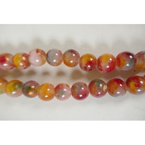 614 - A string of multicolour hardstone/jade mala beads with the remnants of gilt lustre, 122cm long