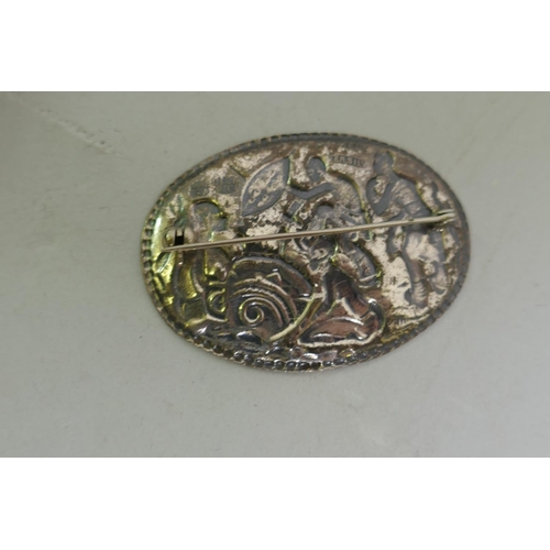 630 - A Candida South African silver brooch decorated with warriors dancing, 53mm long, and a vintage diam... 