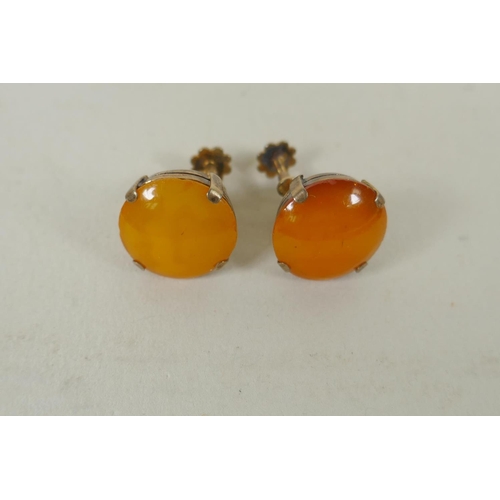 634 - A vintage graduated butterscotch amber necklace and a pair of matching earrings with silver gilt mou... 